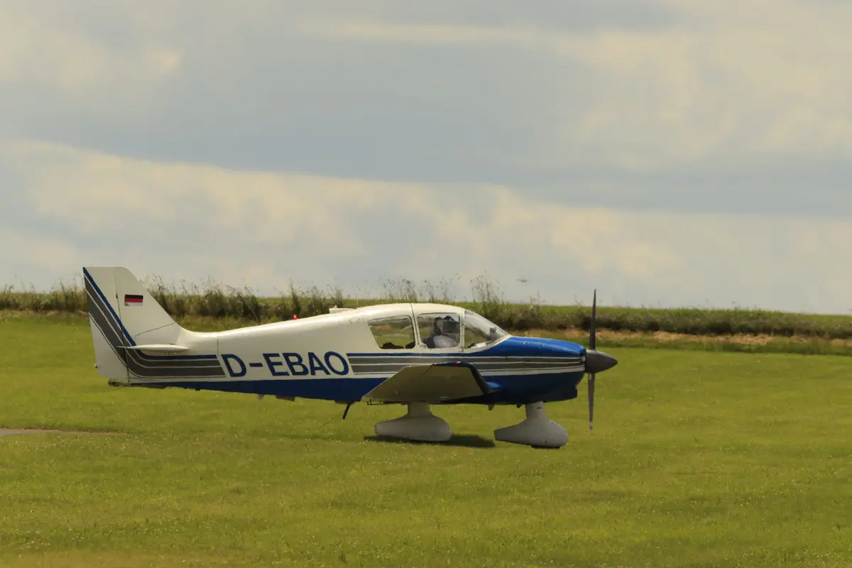 Weiß-blaue Robin D-EBAO beim Rollen über das Gras