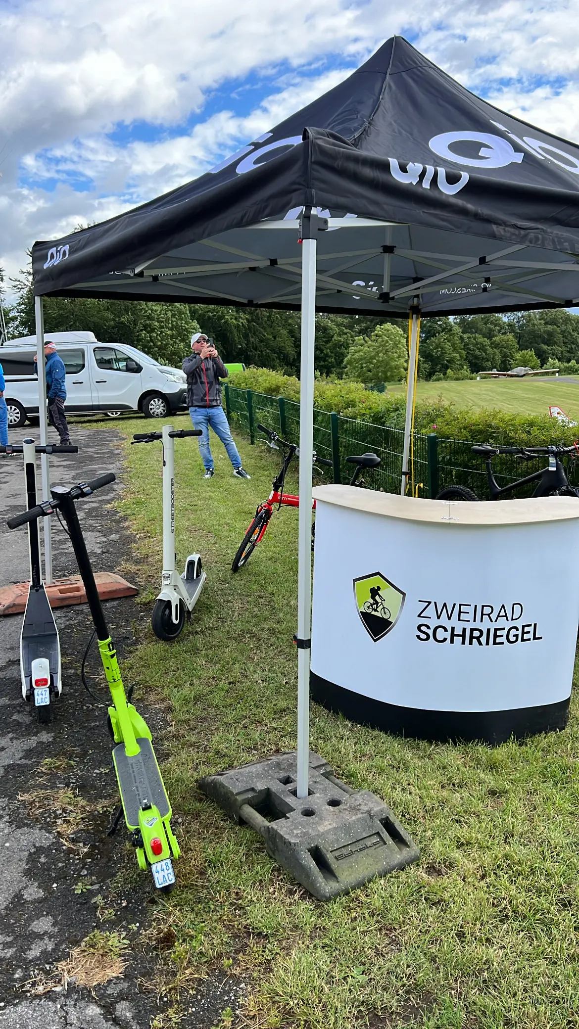 Ausstellerzelt mit E-Scootern auf der Wiese