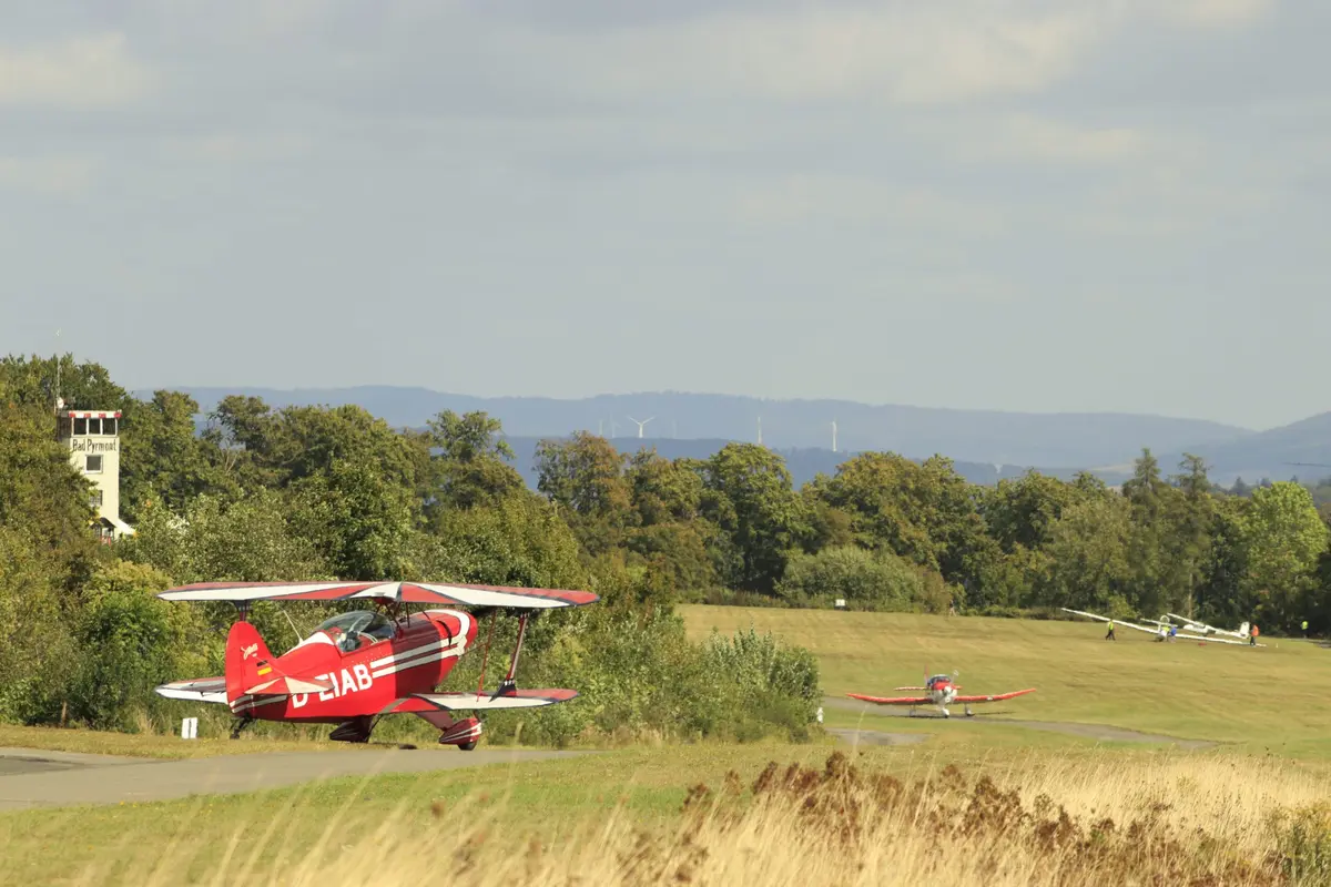 Doppeldecker rollt über das Gras, im Hintergrund der Tower