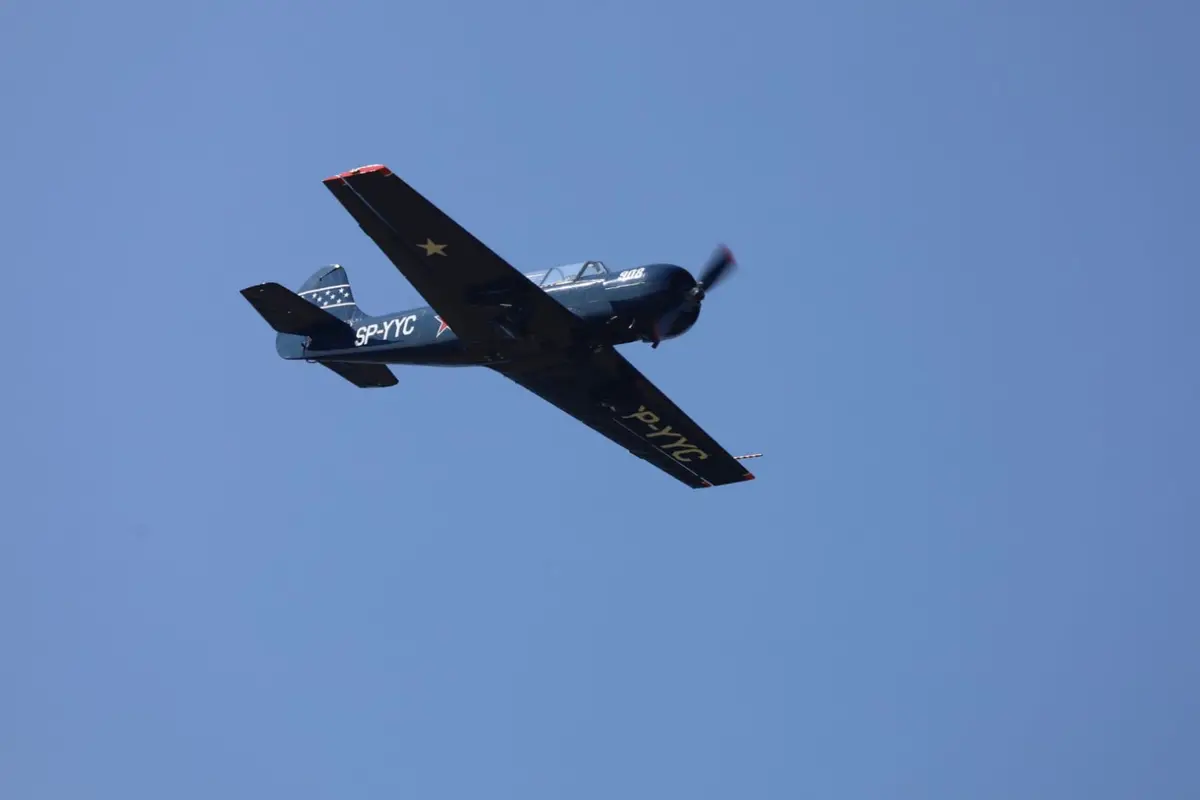 Jak-52 im Überflug vor blauem Himmel