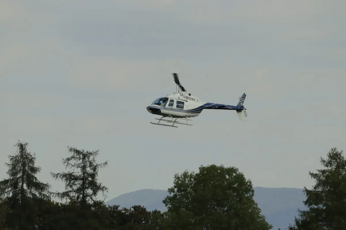 Hubschrauber im Flug über den Bäumen