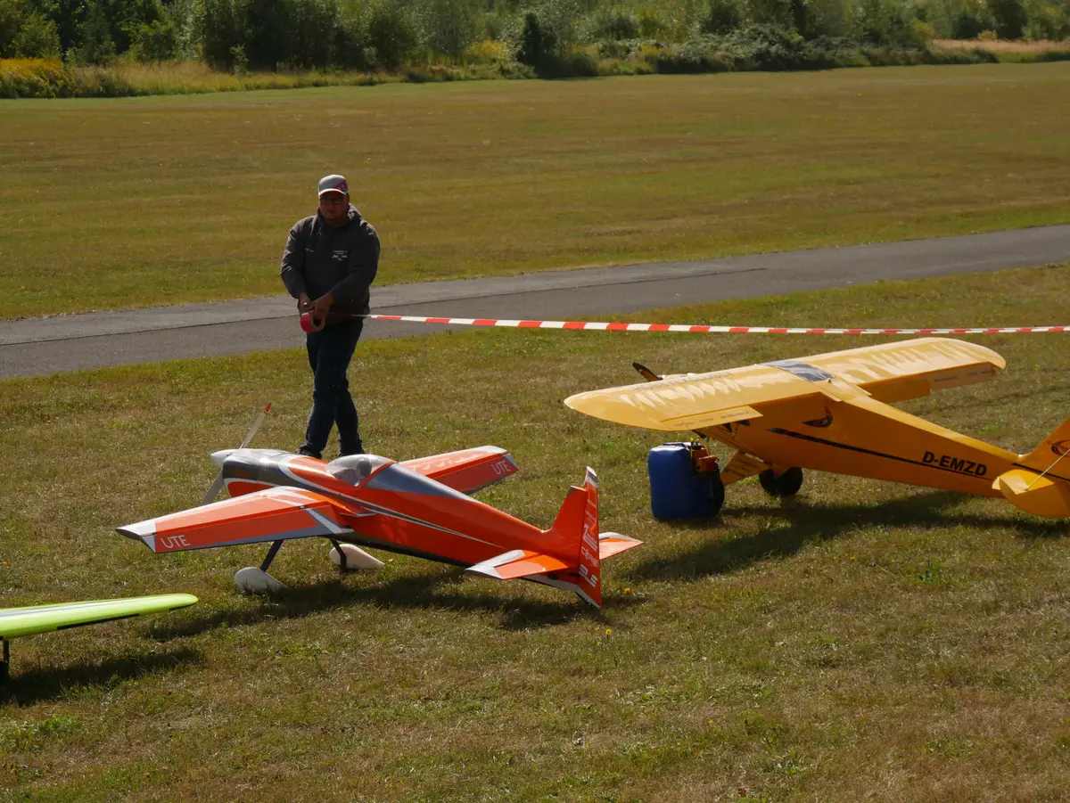 Modellflieger mit Flugmodellen auf der Wiese