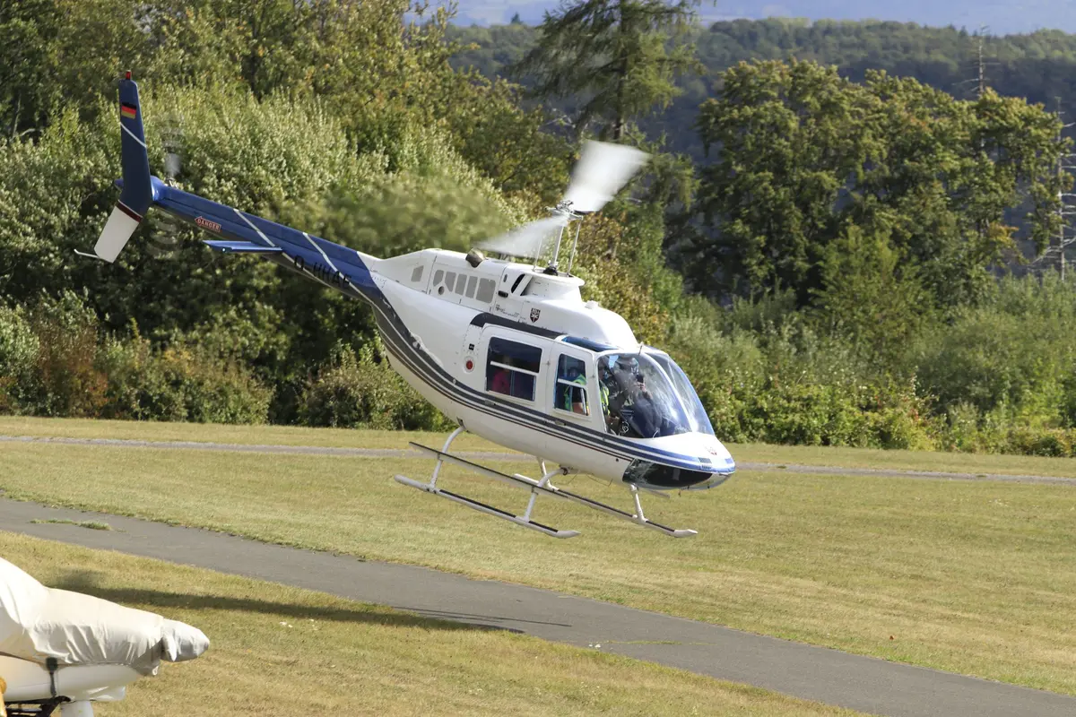 Hubschrauber beim Abheben auf der Wiese